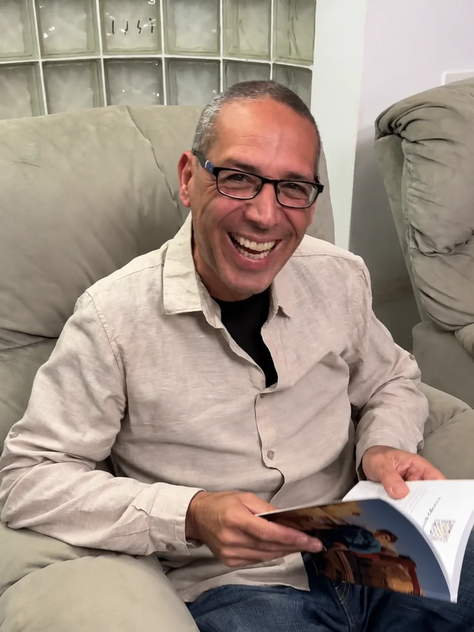 אבא צוחק כשהוא מחזיק את ספר סיפור החיים המודפס שקיבל במתנה